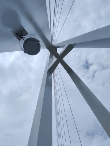 Cloudy white sky through a bridge tower