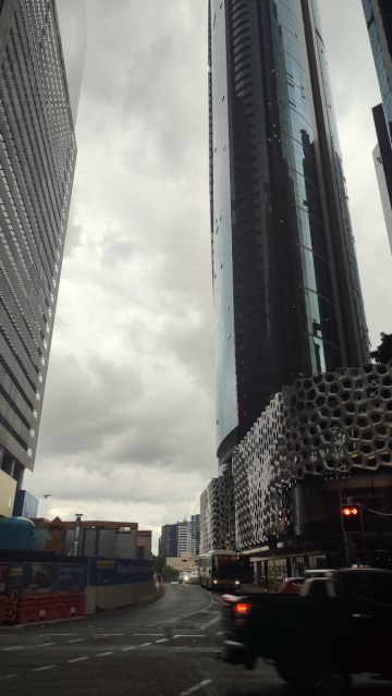 A dark skyscraper looms above traffic