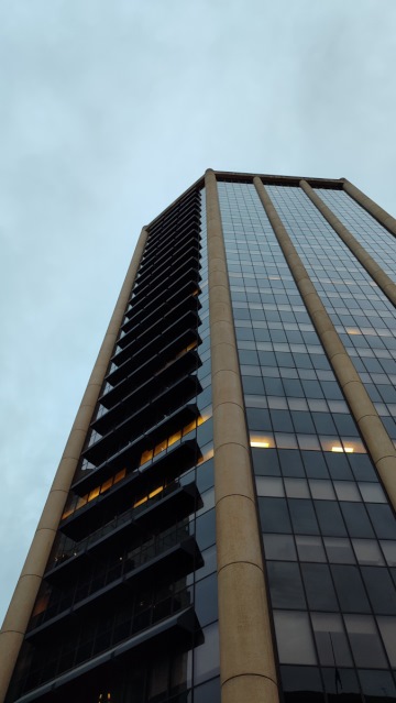 Looking up at a tall building on a rainy day