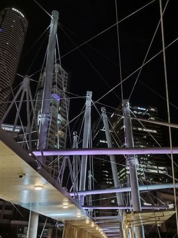 Criss-crossed wires of a bridge lit up at night